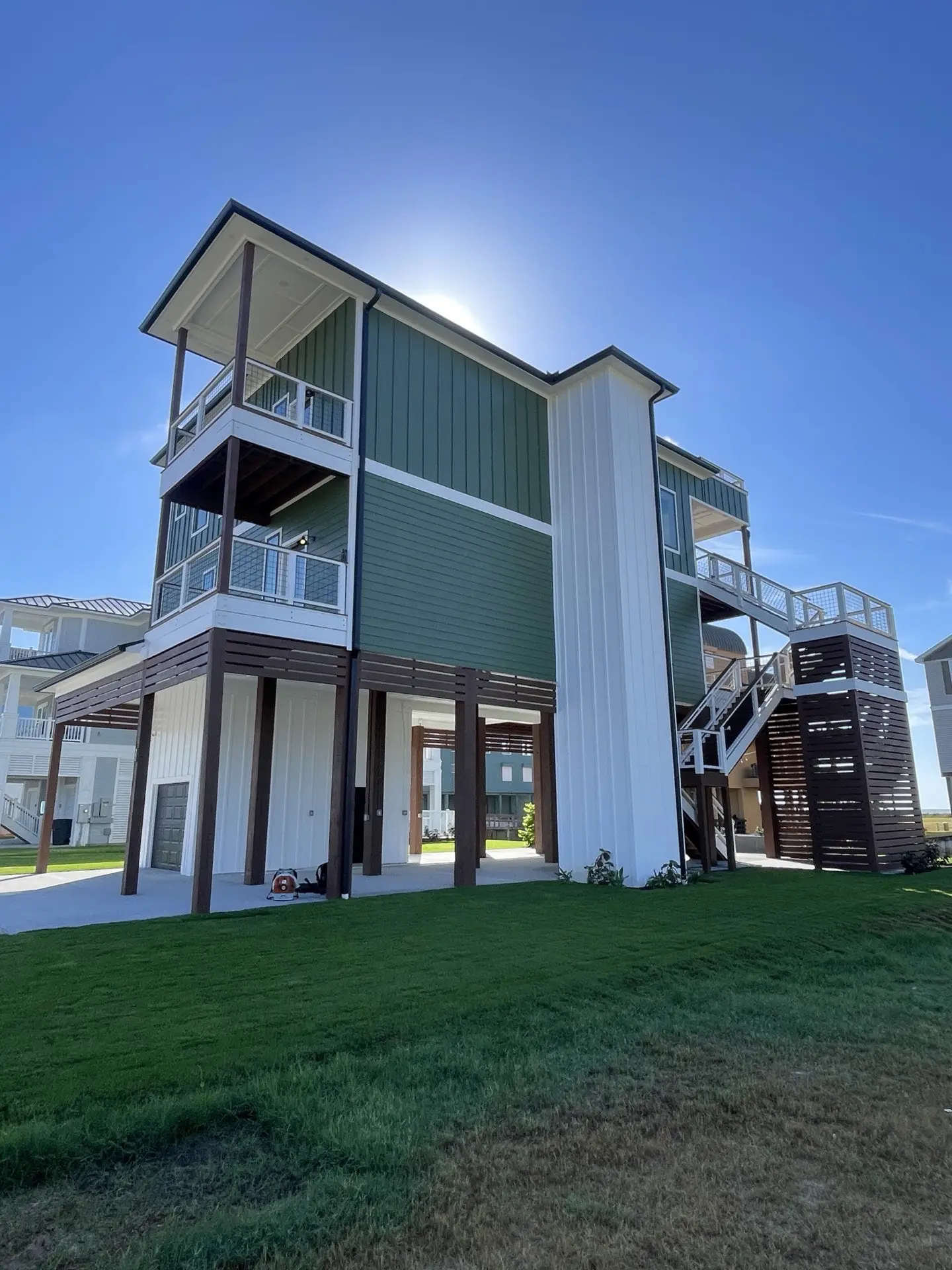 Designer bathroom featuring pebble mosaic shower floor, emerald accent tile niche, and brushed gold rain showerhead
