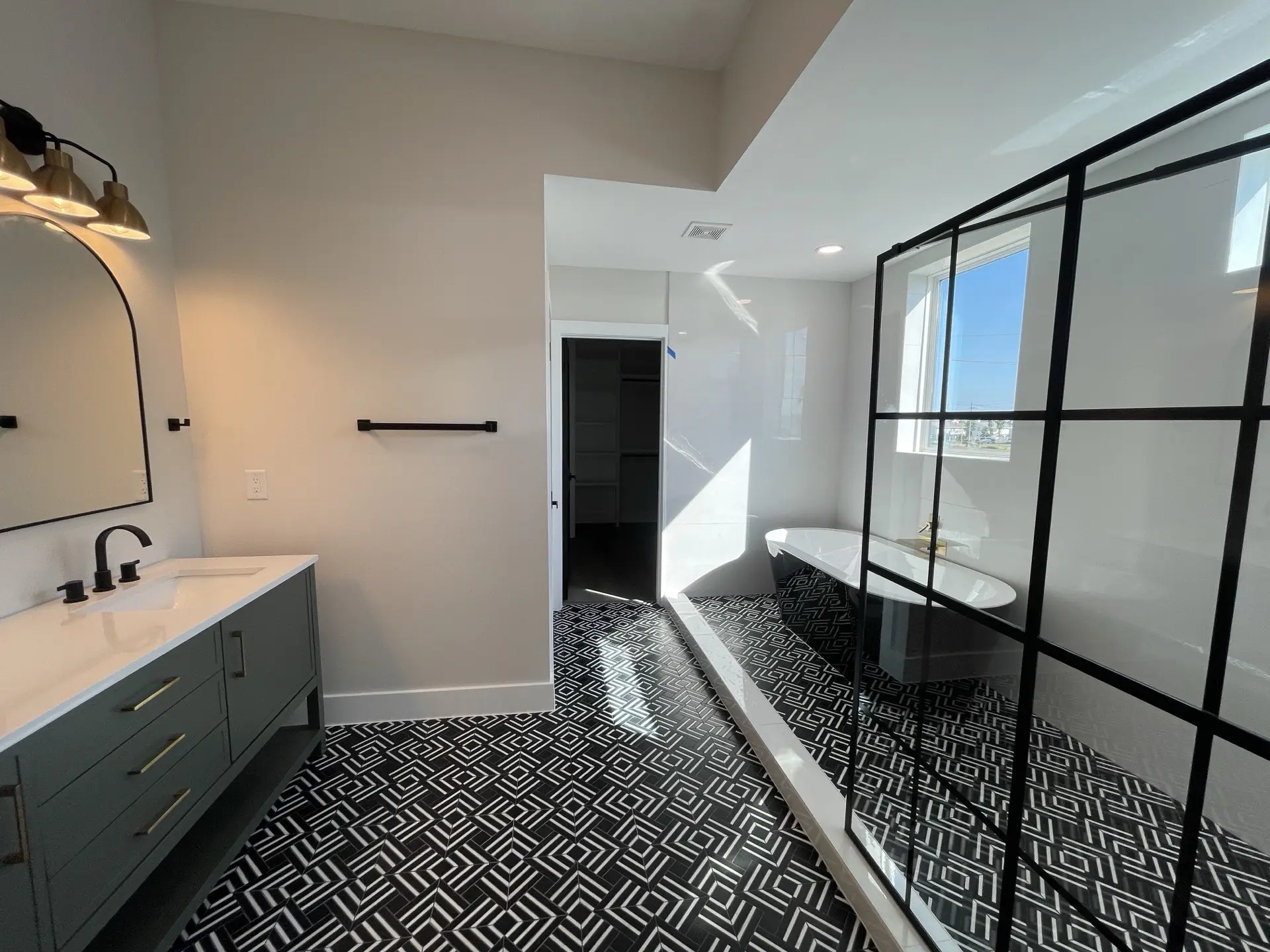 View through the open floor plan showing the seamless flow between living, dining, and kitchen areas with luxury contemporary finishes
