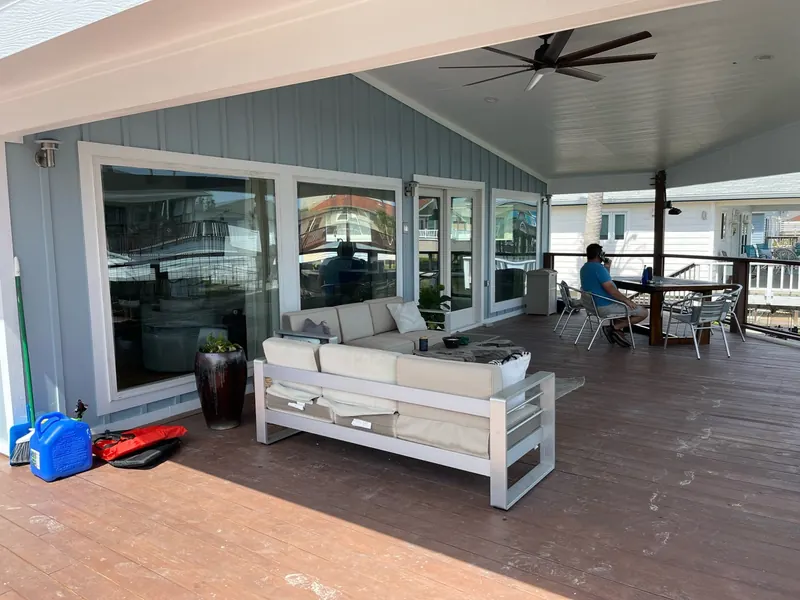 After: rebuilt covered deck at the Flounder renovation with a large ceiling fan, painted ceiling, and outdoor seating