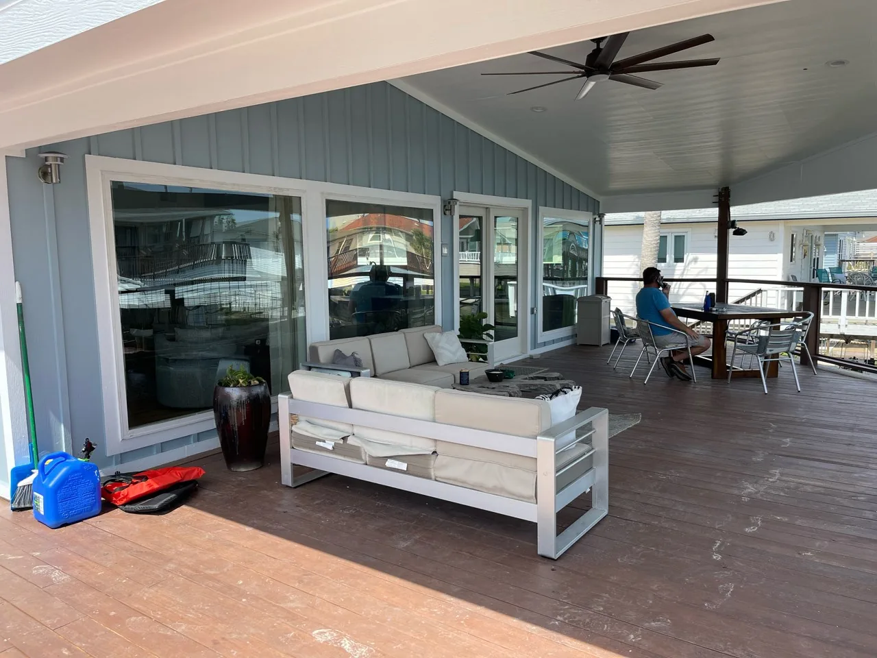 After: rebuilt covered deck at the Flounder renovation with a large ceiling fan, painted ceiling, and outdoor seating