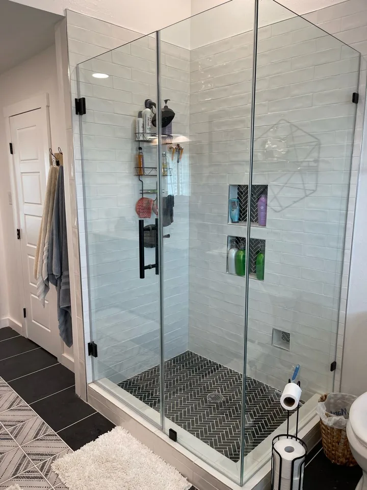 After: frameless glass shower in the renovated Flounder bath with large-format wall tile and mosaic flooring