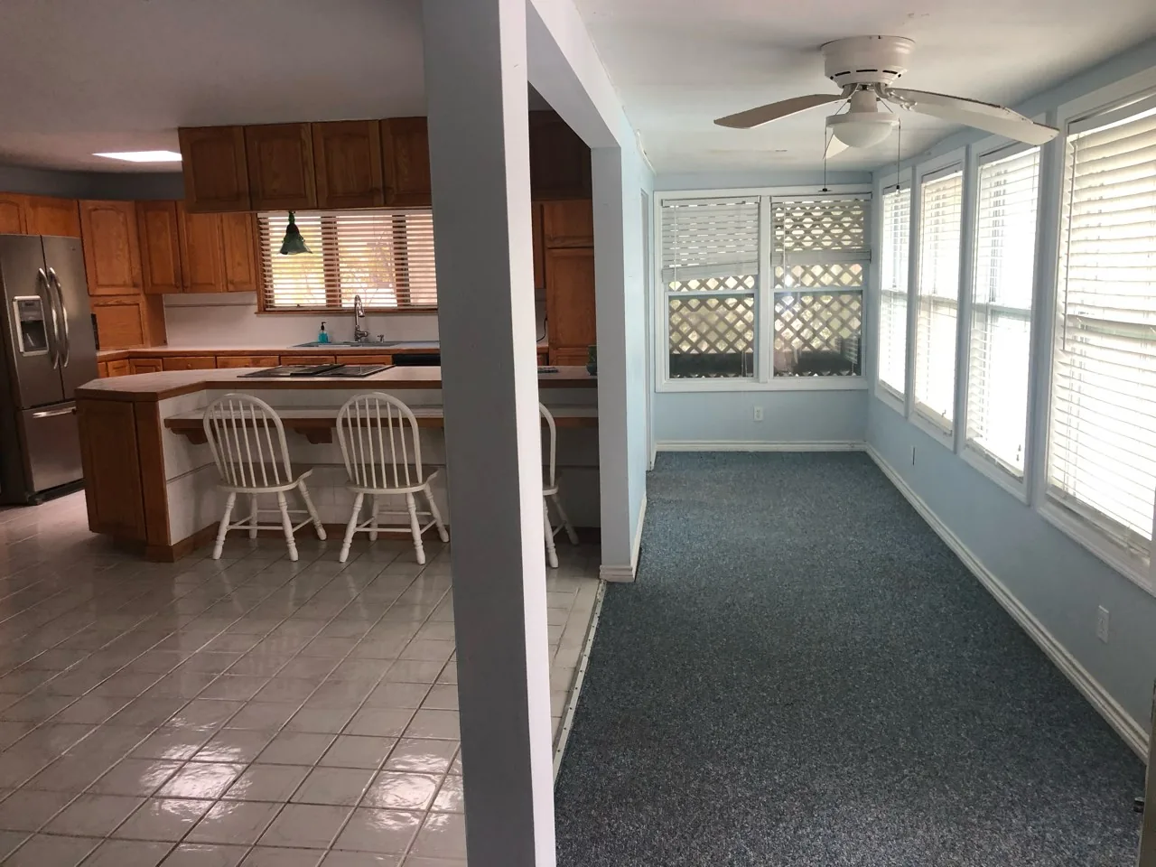 Before: view from the original kitchen through to the enclosed sunroom, separated by a structural wall