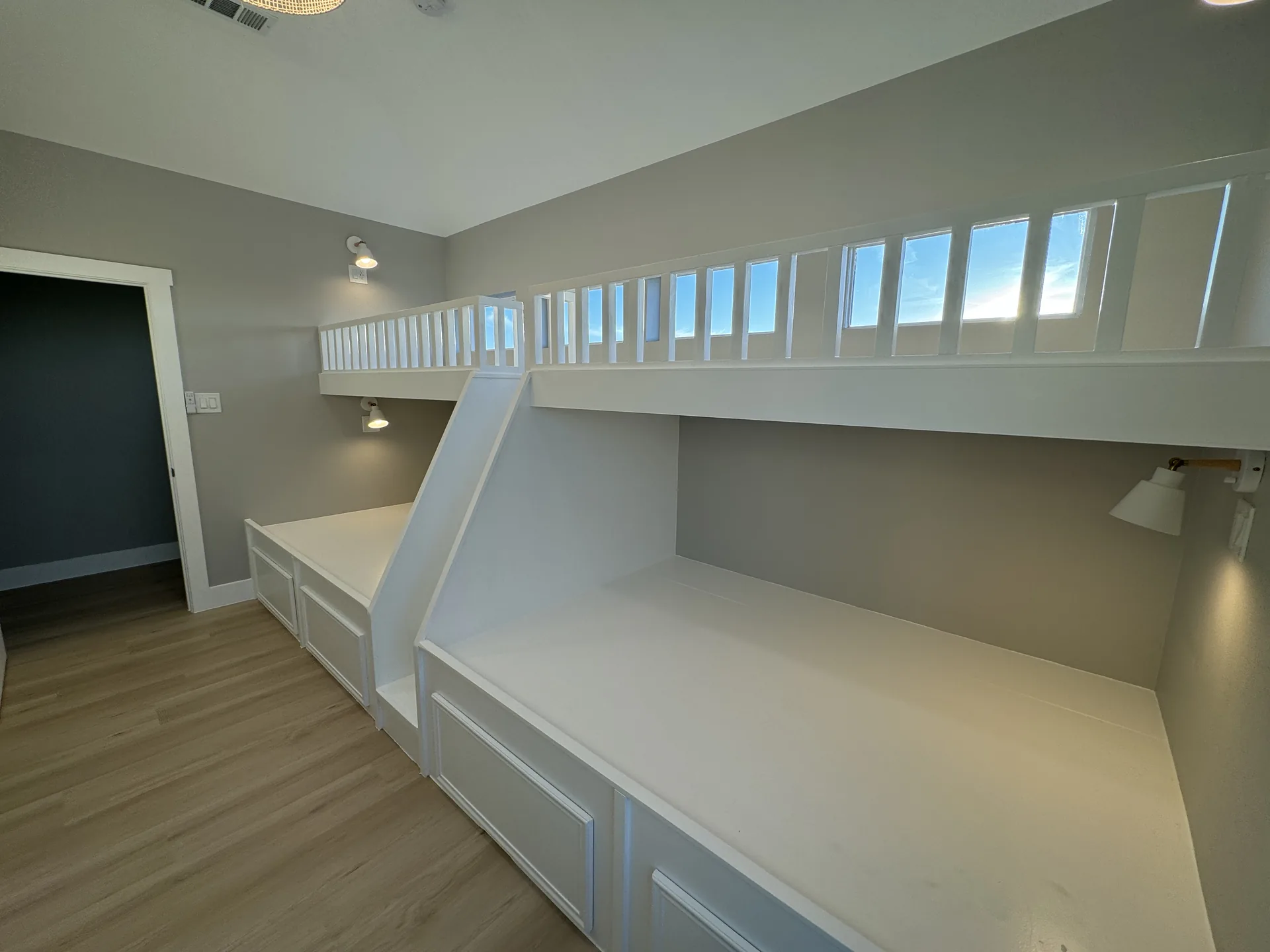 Built-in bunk room at Galleon with custom white bunks and a clerestory window run above