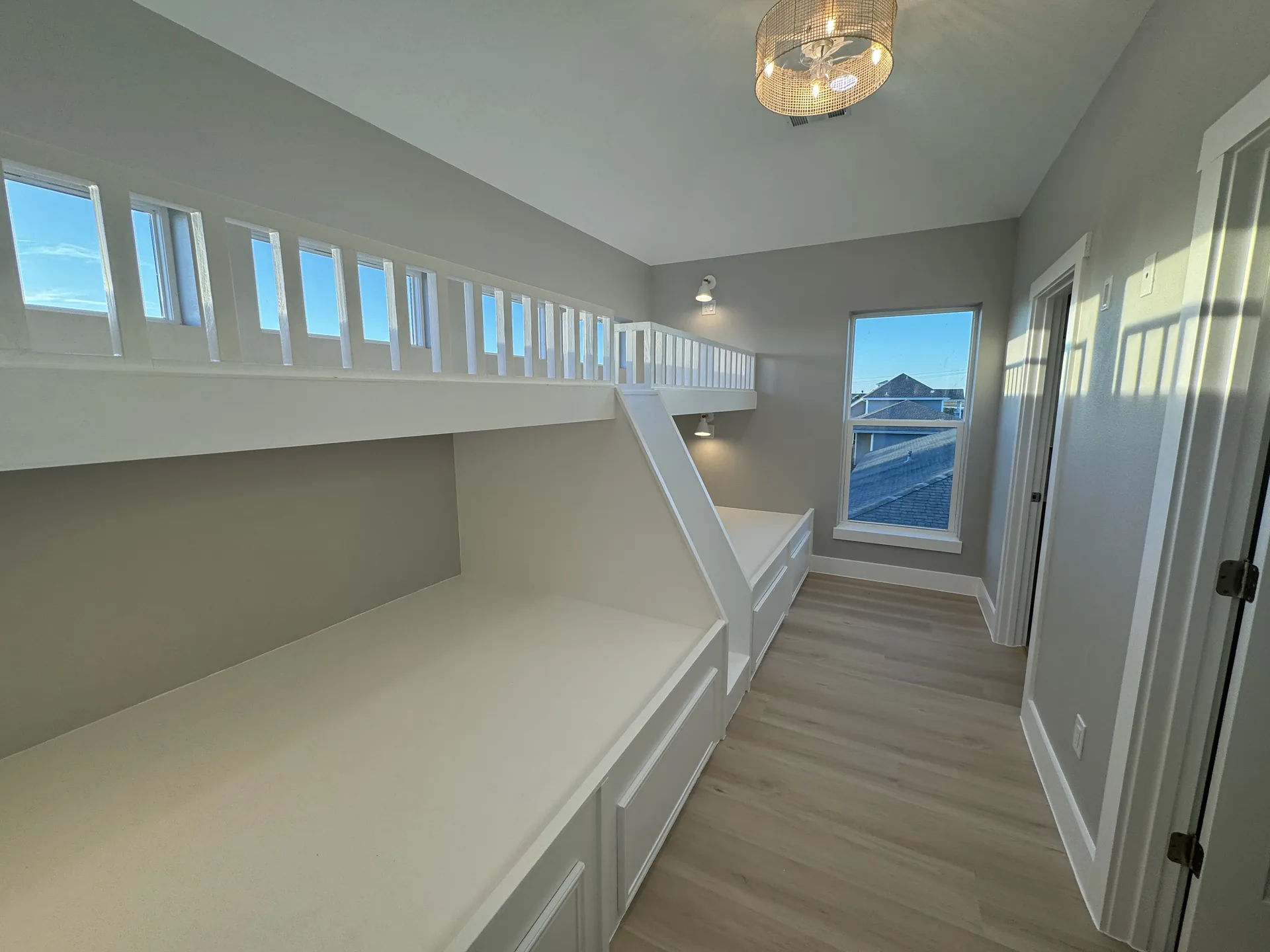 Wide view of the Galleon bunk room showing the built-in beds, ladder, and natural light from the window band
