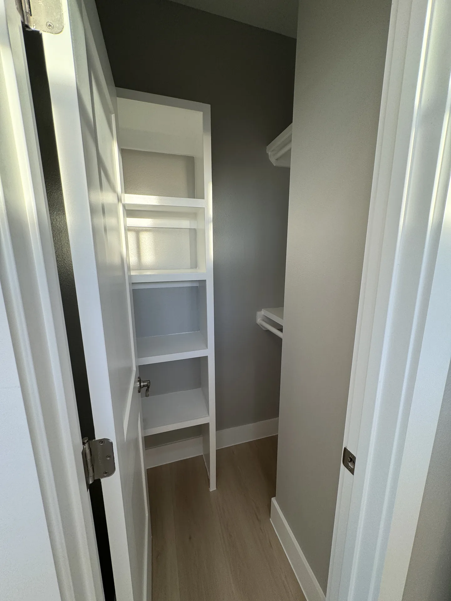 Custom built-in linen and storage closet with white shelving in the Galleon hallway