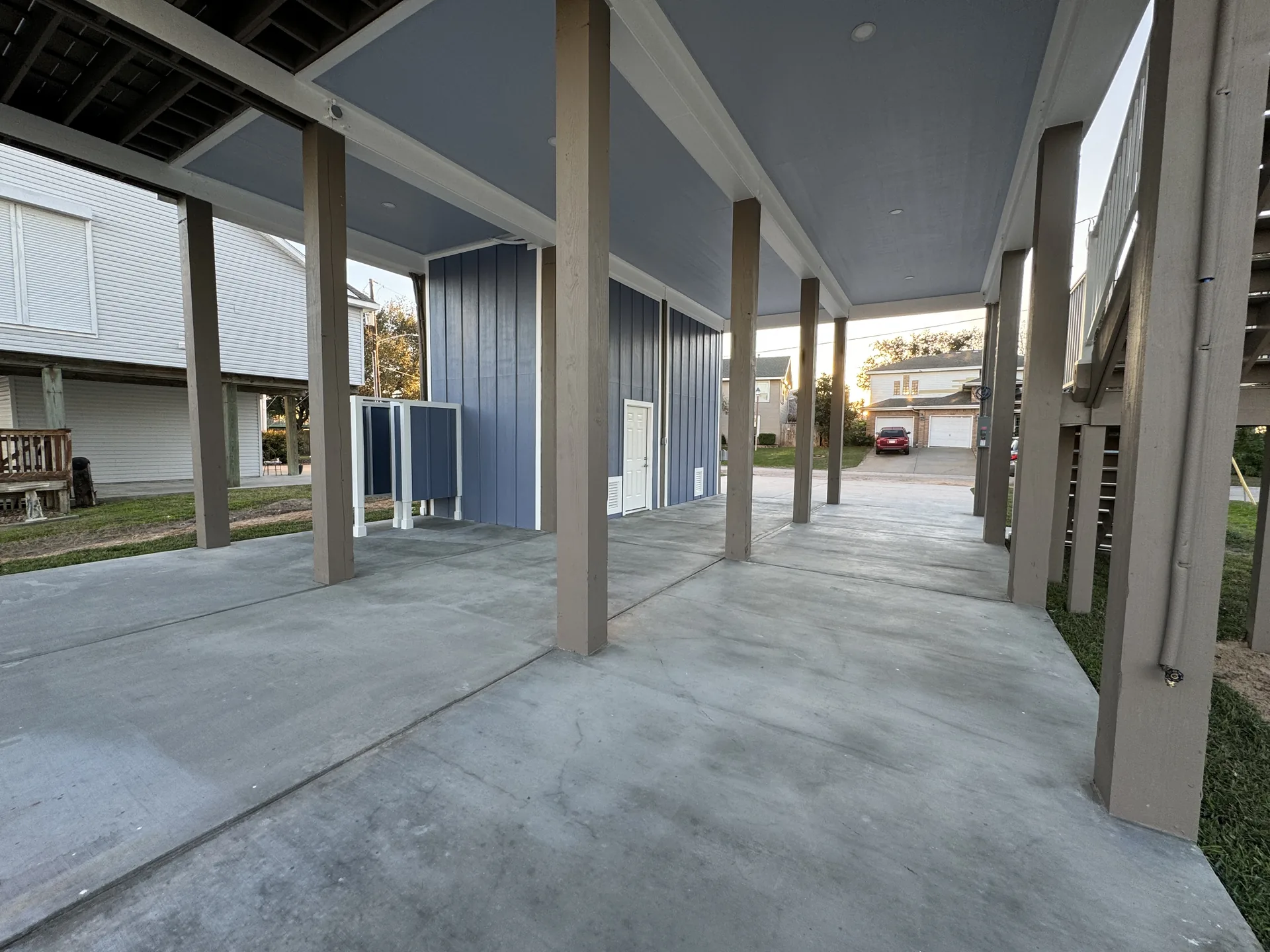 Ground-level parking and covered entertaining area beneath the elevated Galleon home, finished with a poured concrete slab