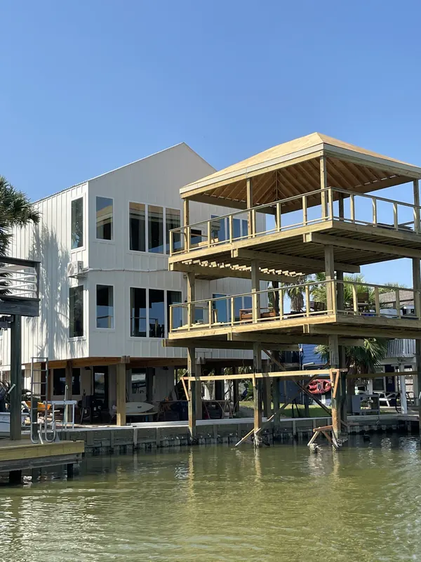Waterfront elevation of the Jamaica Beach addition showing the new private boat dock and stacked multi-level decks stepping down to the canal