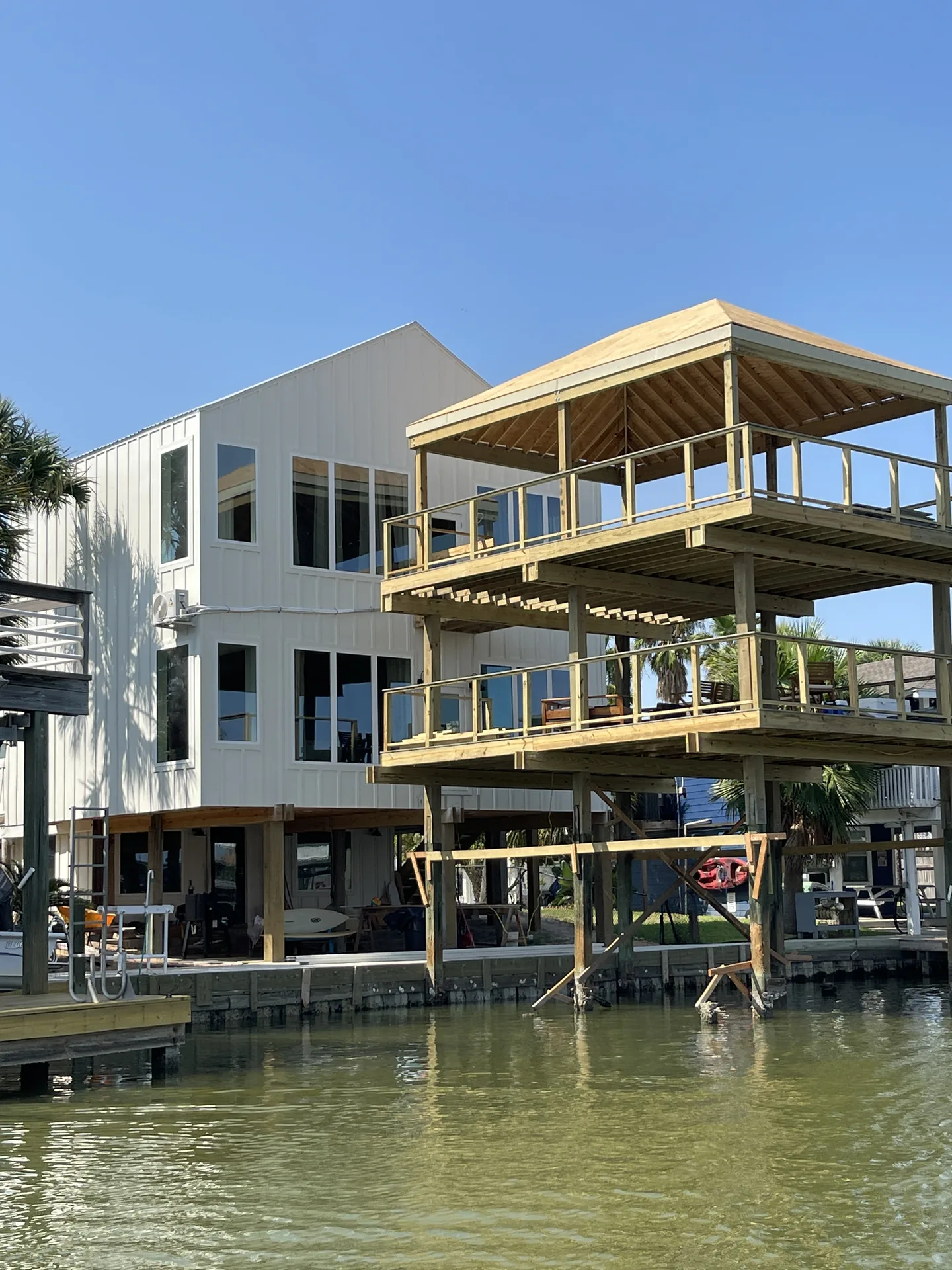 Waterfront elevation of the Jamaica Beach addition showing the new private boat dock and stacked multi-level decks stepping down to the canal