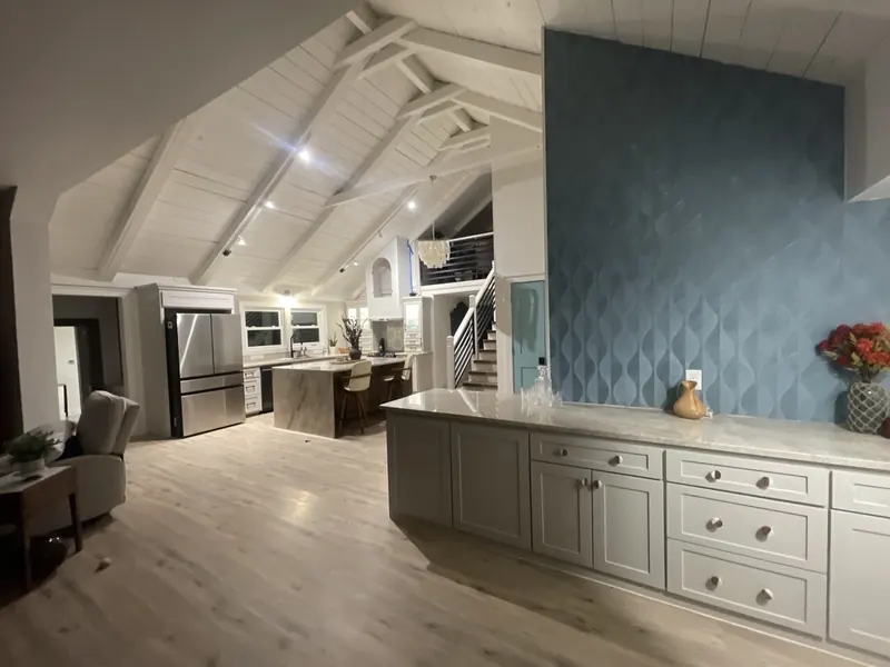 Great room of the Jamaica Beach addition with a vaulted whitewashed shiplap ceiling and a textured blue tile feature wall