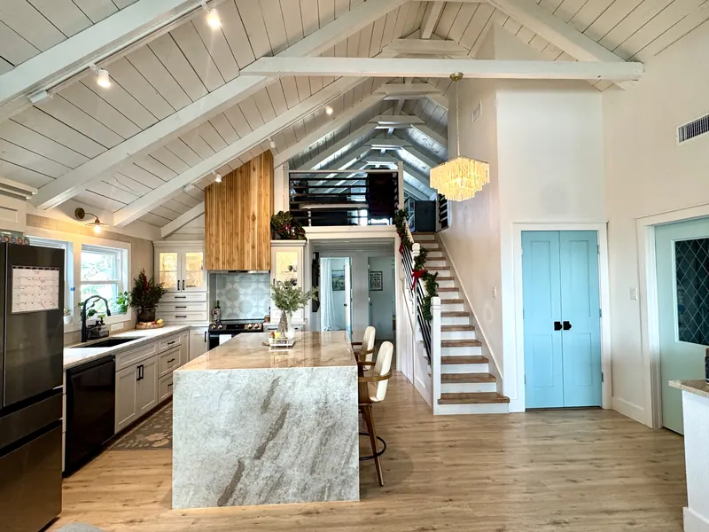 Quartz waterfall island in the Jamaica Beach kitchen addition, set beneath the vaulted shiplap ceiling