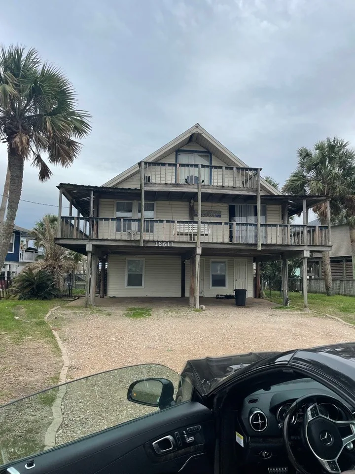 Before: side elevation of the original Jamaica Beach house showing the two-level deck and dated cladding