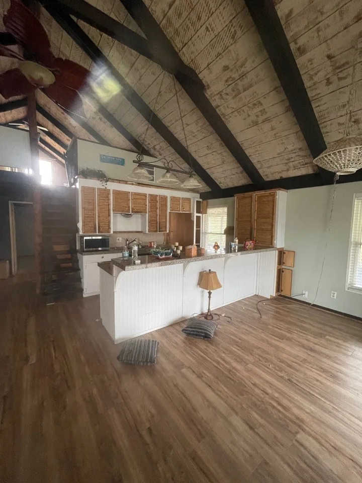 Before: original kitchen pushed against the wall with laminate counters and a bar-height divider
