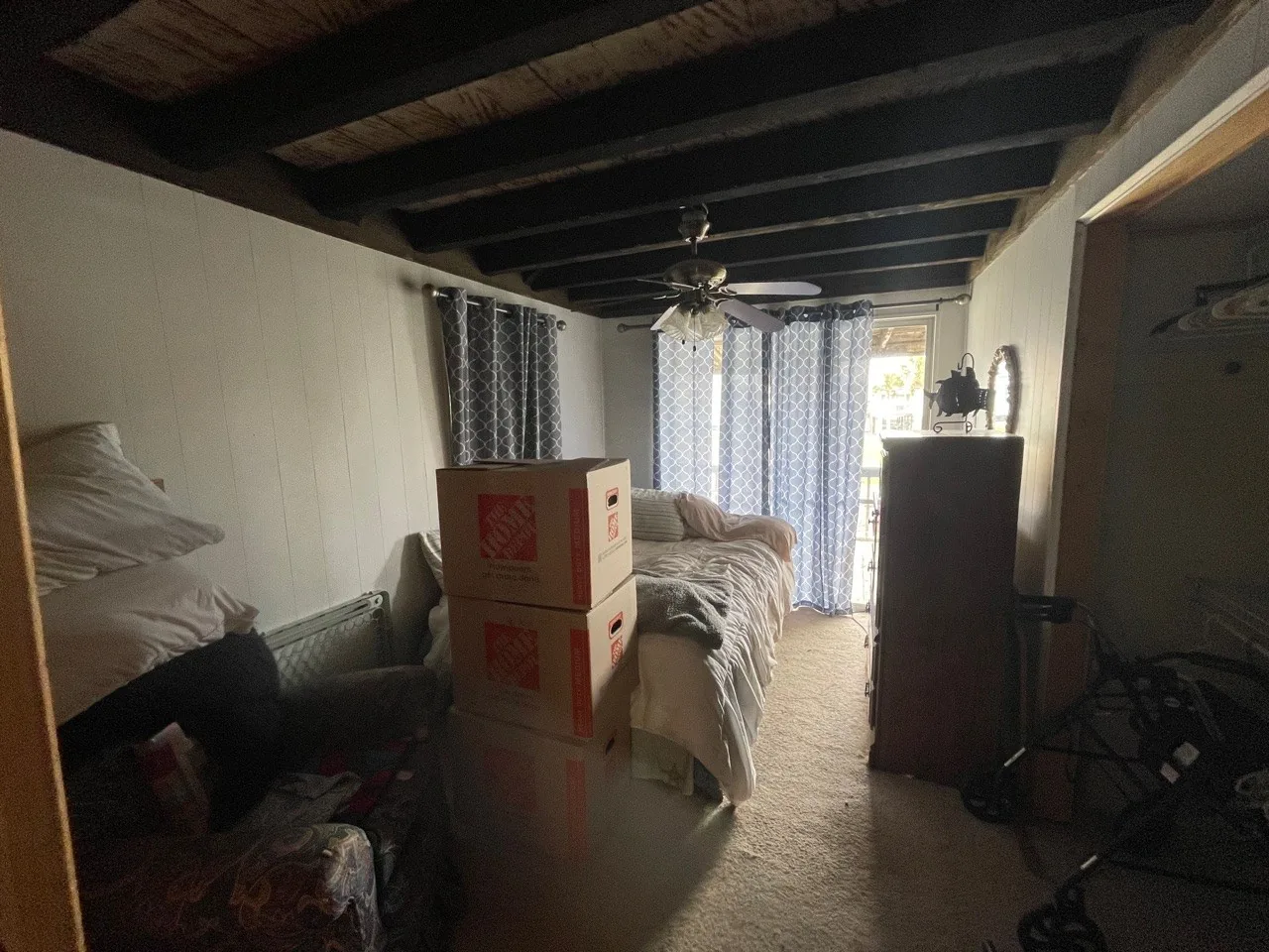 Before: original living space mid-move-out with furnishings and boxes still in place
