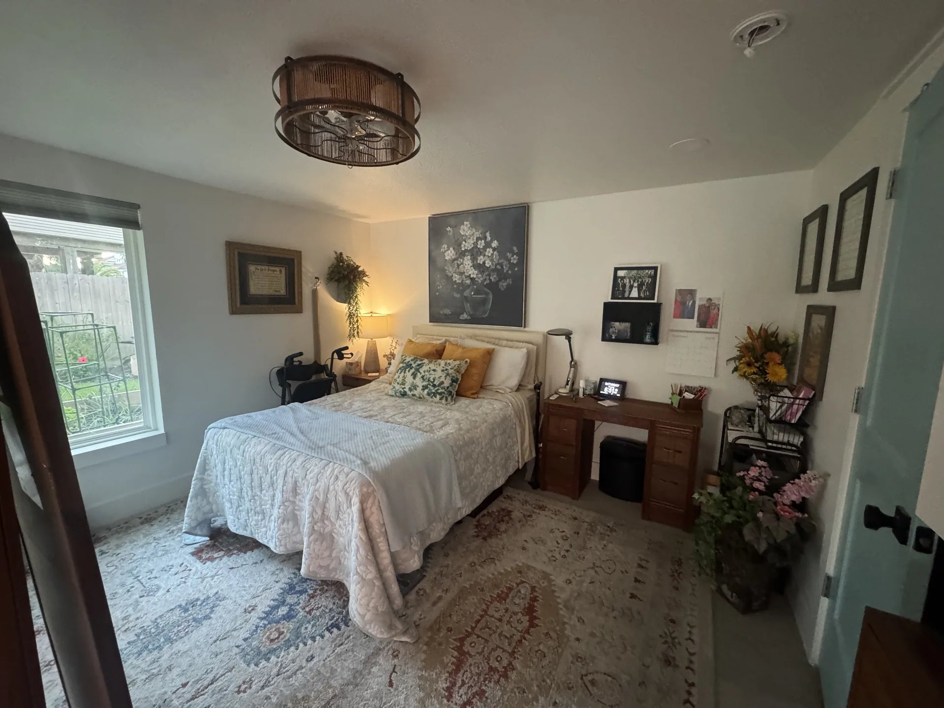 Renovated bedroom in the Galveston one bedroom conversion, with a made bed, layered area rug, and natural light from the window