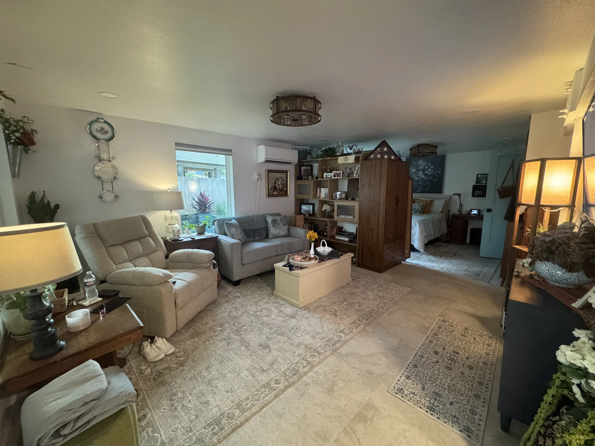 Living area of the Galveston one bedroom renovation with seating, warm neutral finishes, and a view through to the bedroom