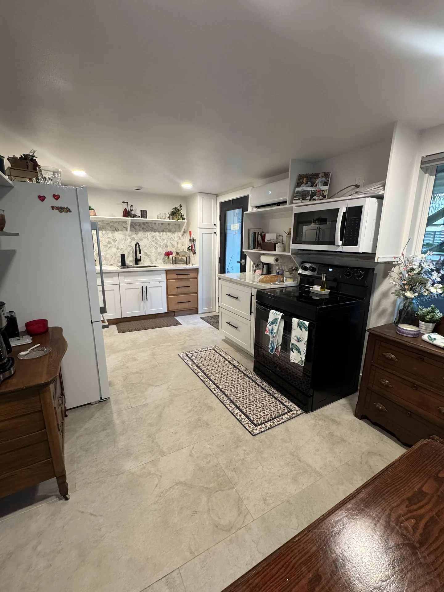 Renovated galley kitchen in the Galveston one bedroom conversion with white cabinetry and quartz counters