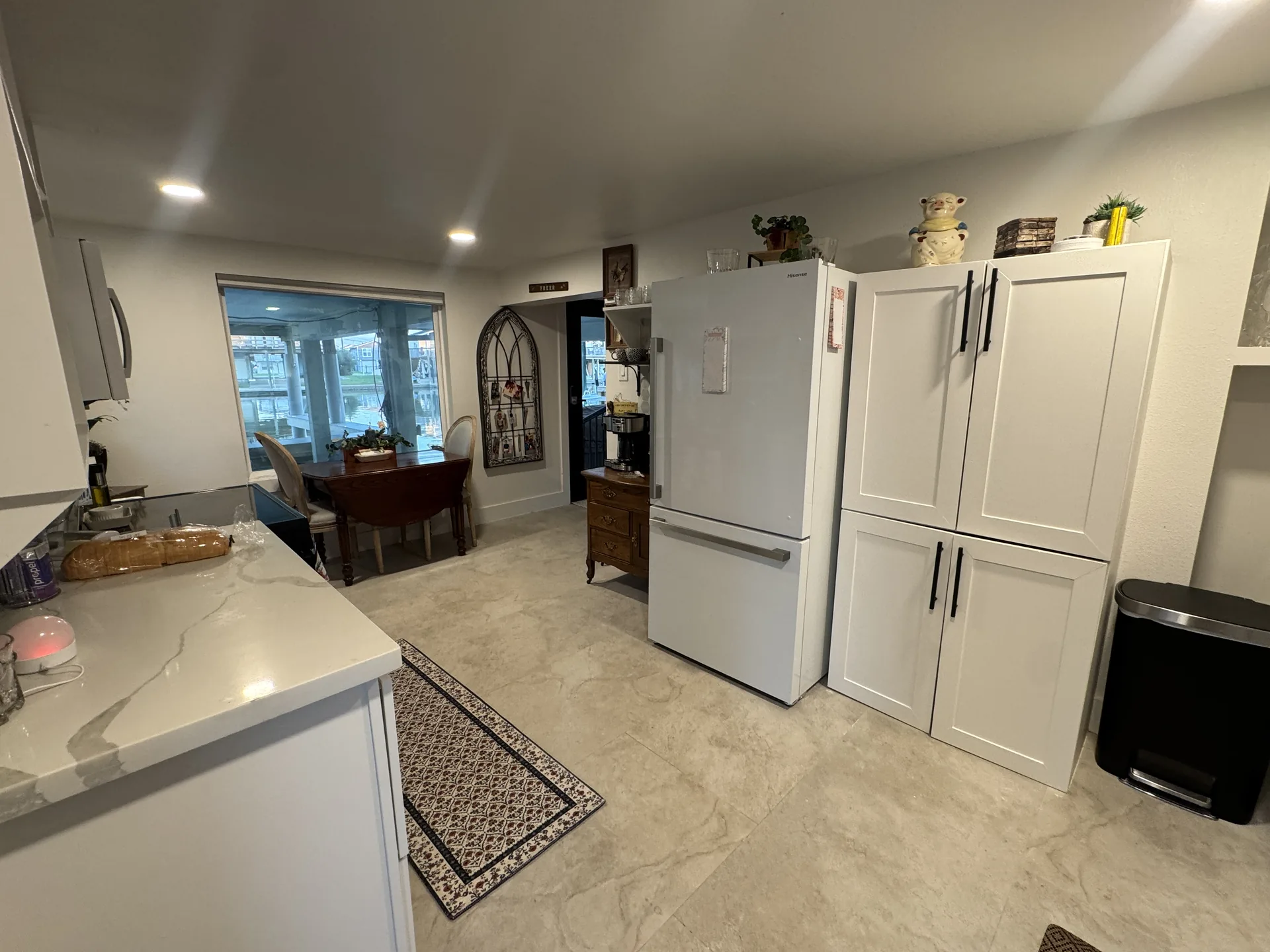 Kitchen of the one bedroom renovation showing the full-height pantry cabinetry, refrigerator, and quartz-topped peninsula