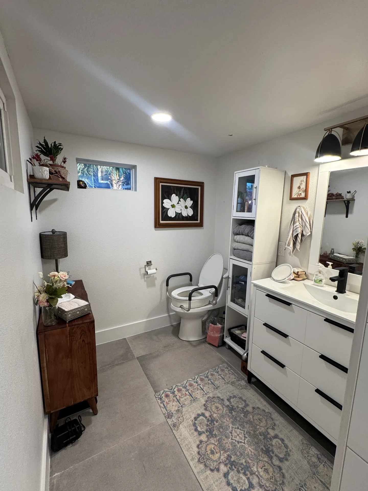 Renovated bathroom vanity in the Galveston one bedroom conversion with white drawers and tile flooring