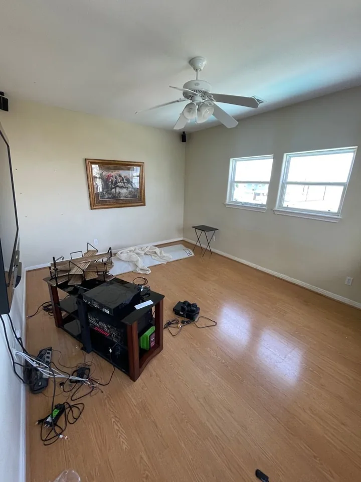 Before: original bedroom mid-demolition with furnishings removed and flooring exposed