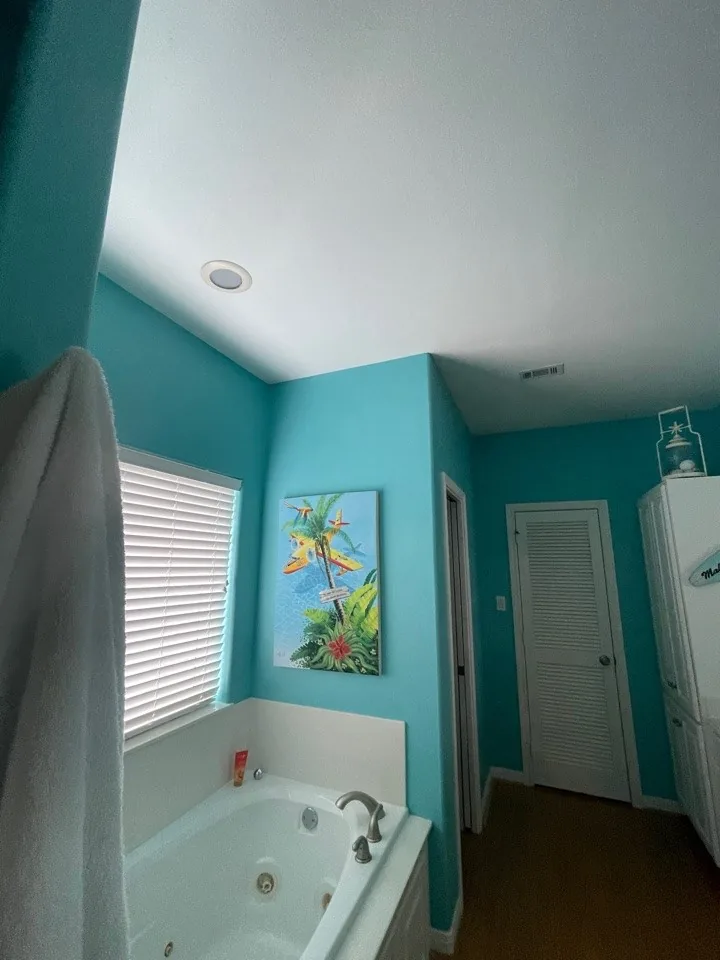 Before: original primary bath jetted corner tub set against teal walls