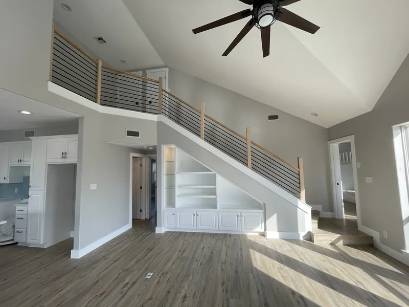 After: renovated great room and staircase at Tern with a horizontal open rail and built-in cabinetry