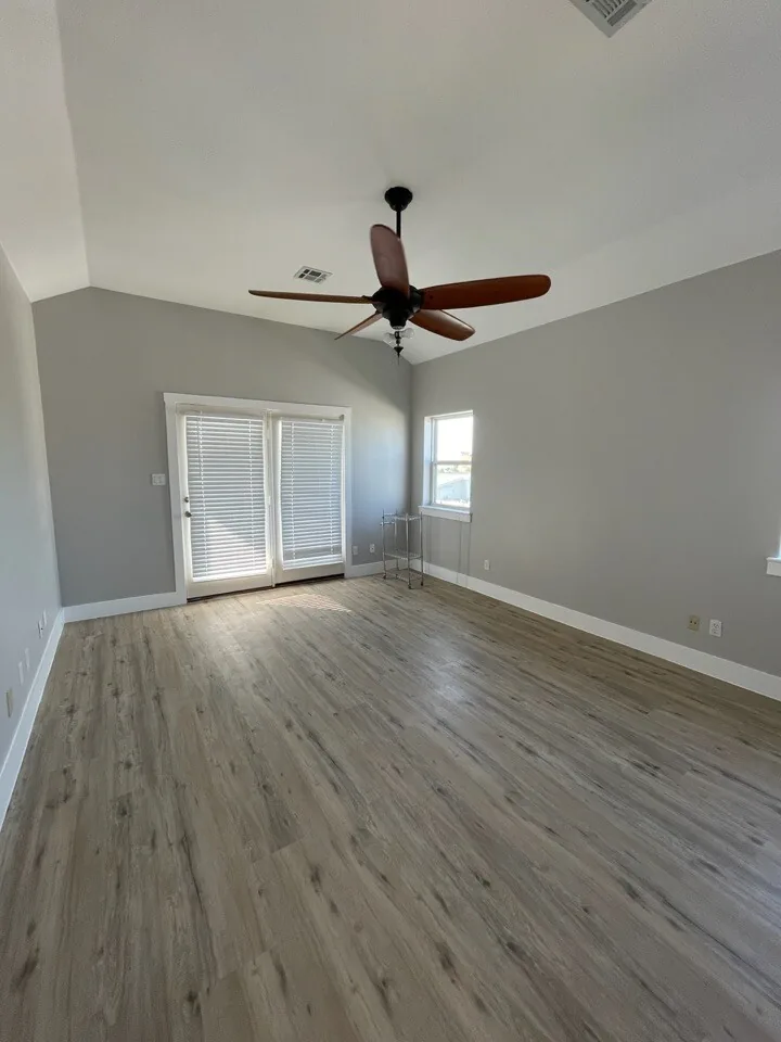 After: renovated living area at Tern with new flooring, vaulted ceiling, and doors to the deck
