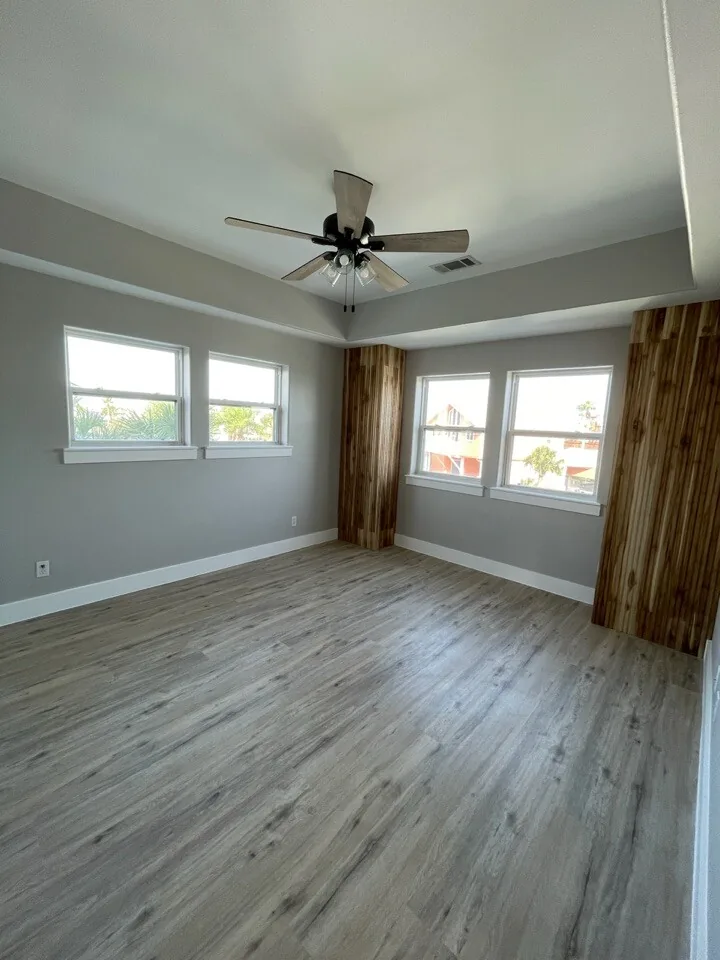 After: renovated bedroom at Tern with a cedar accent wall, new flooring, and corner windows