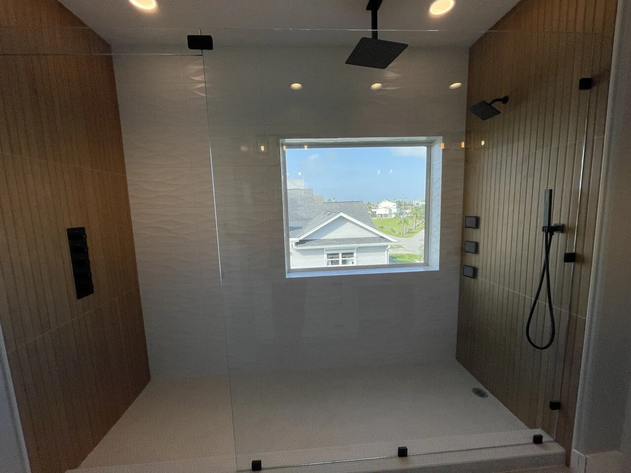 After: wide view of the renovated Tern walk-in shower with full-height tile and frameless glass