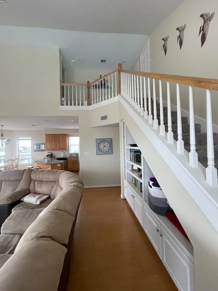 Before: original living space looking up to the loft, closed off by a white spindle railing
