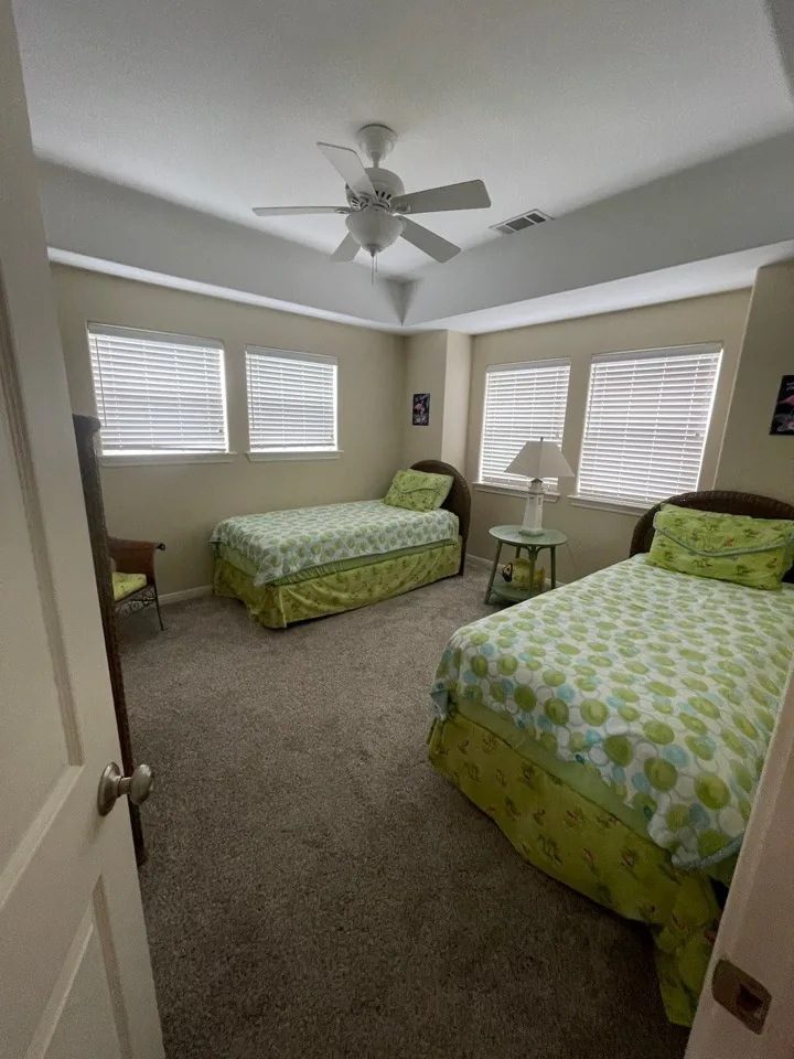 Before: original bedroom with wall-to-wall carpet, twin beds, and mini-blinds