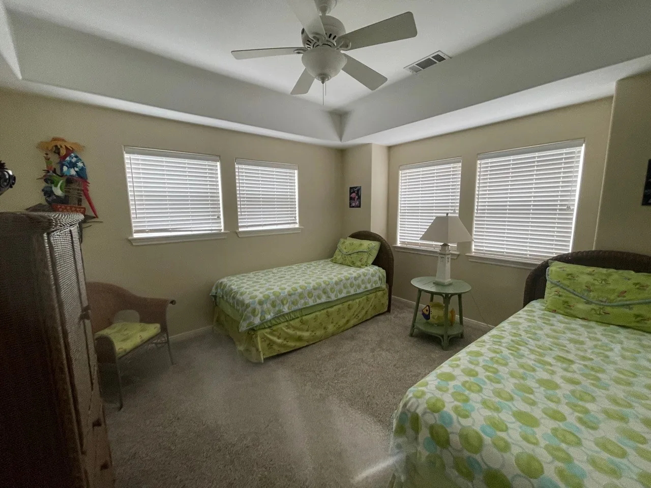 Before: original guest bedroom with carpet, twin beds, and a dated ceiling fan