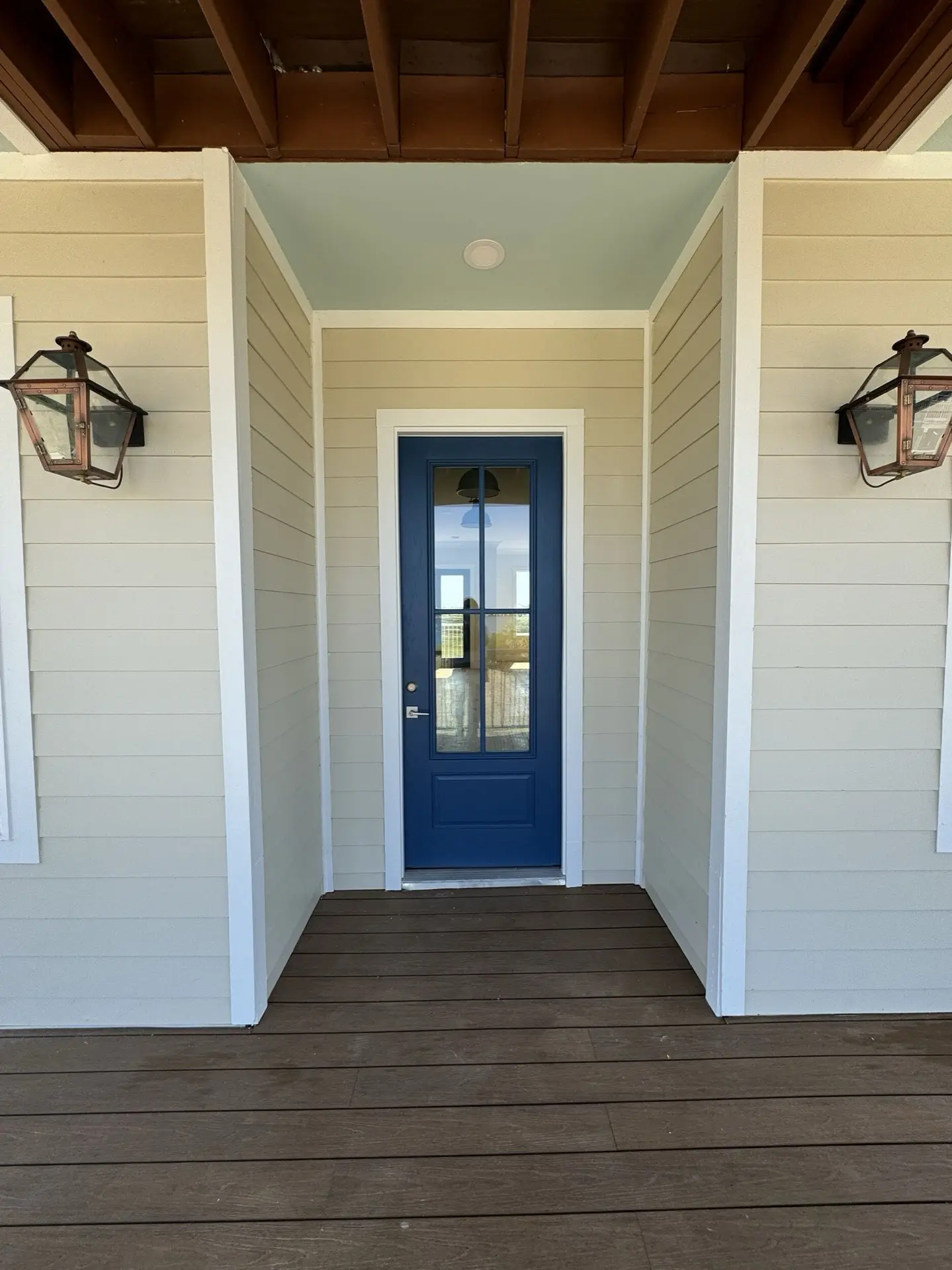 Kitchen workspace with glass-front upper cabinets, sage lower cabinets, marble-look countertop, and integrated stainless steel appliances
