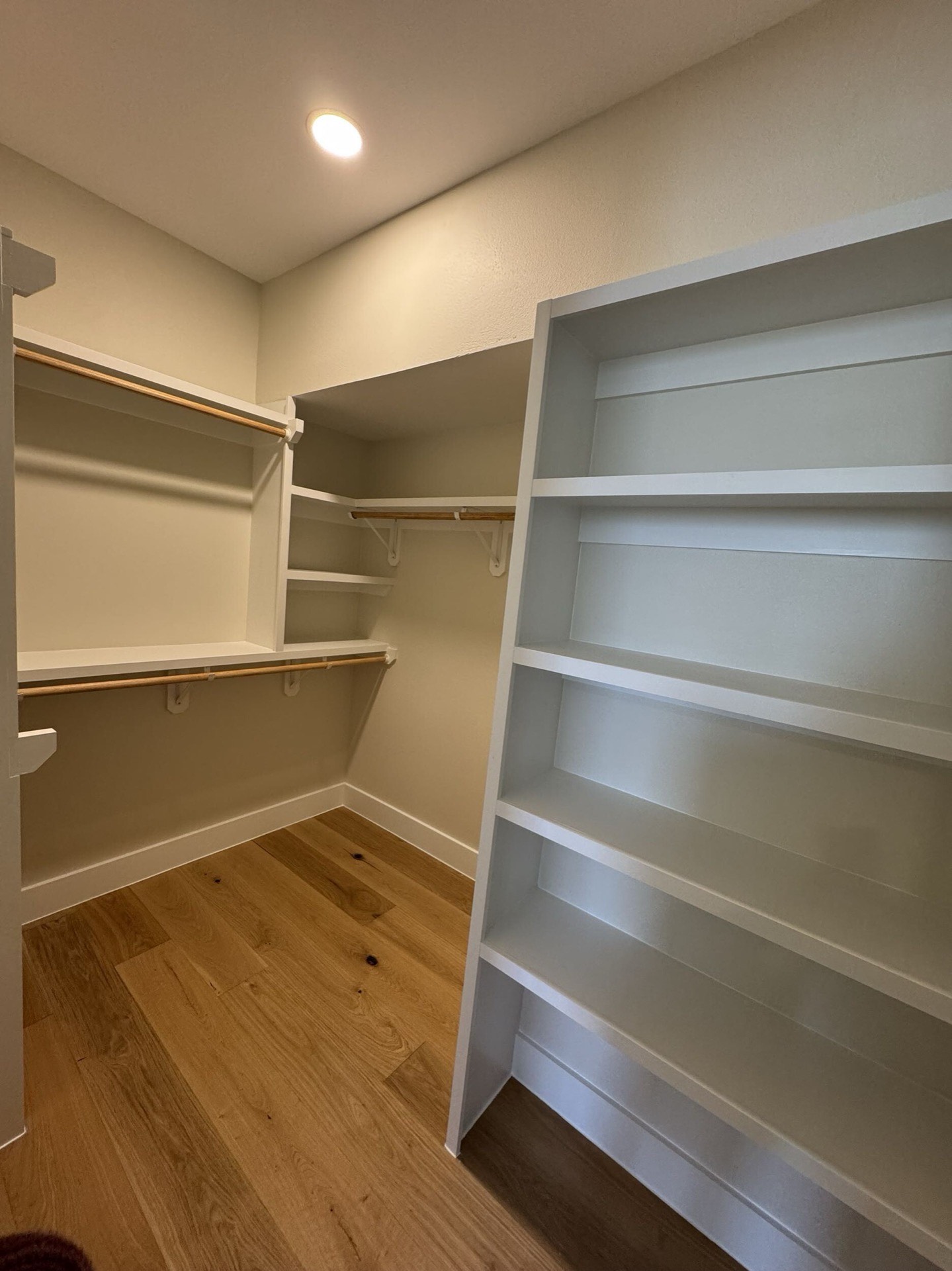 Guest bedroom with oak hardwood flooring, crown molding ceiling detail, and natural light from the West Bay waterfront property