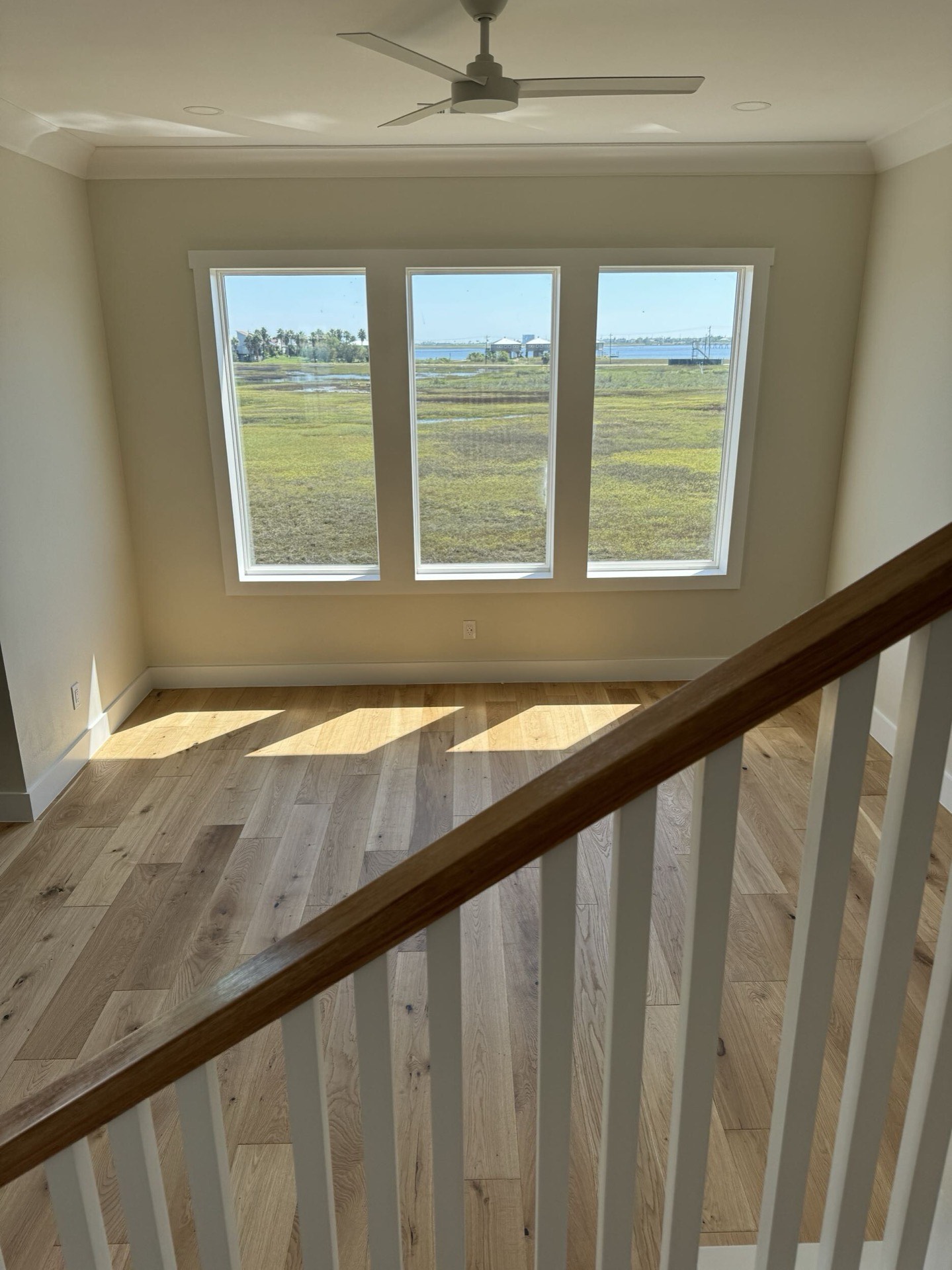 Double-stacked porch view showing both levels of covered outdoor living space with white railings overlooking Galveston Bay